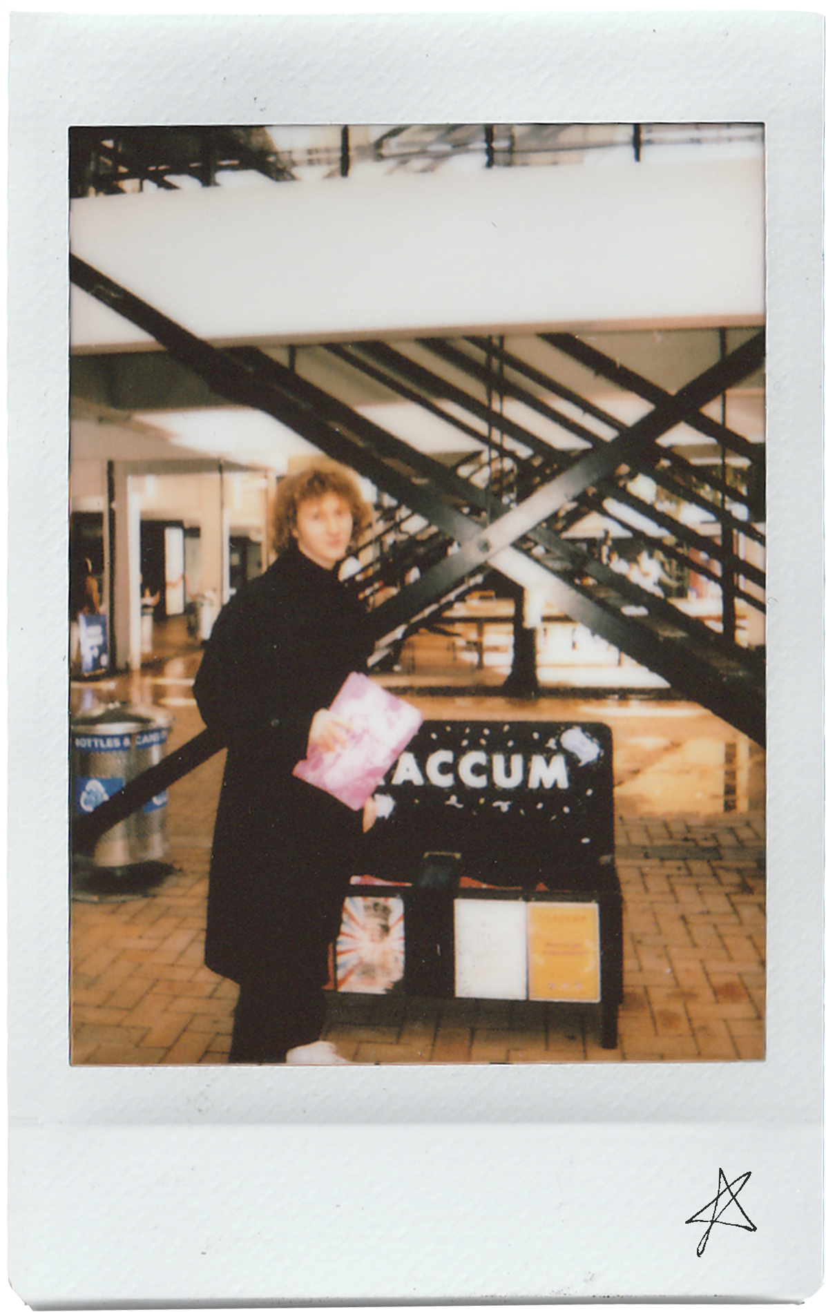 Polaroid Photo of Sebastian standing in front of a stack of Craccum magazines, for an issue featuring one of his articles.